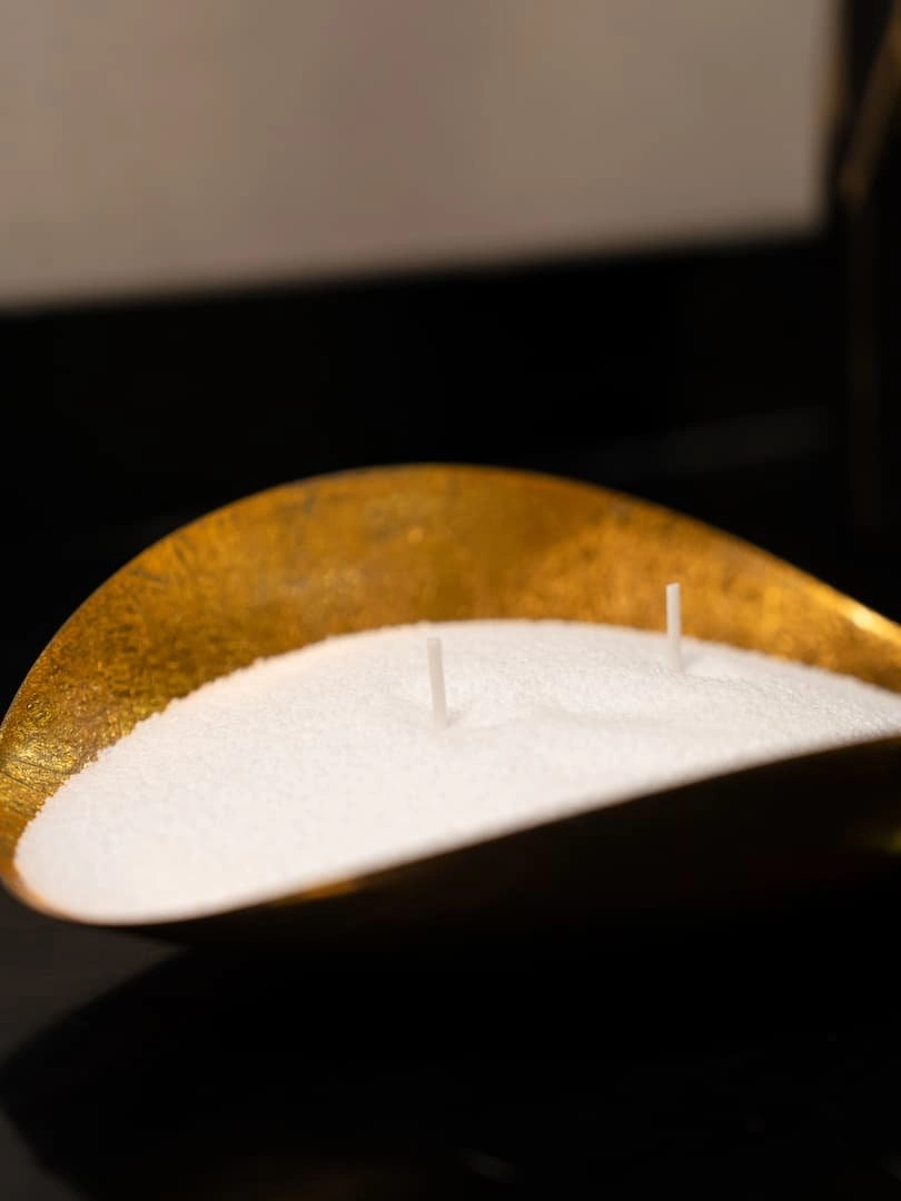 Perles de bougie Lueur Perlée présentées dans un joli contenant doré.