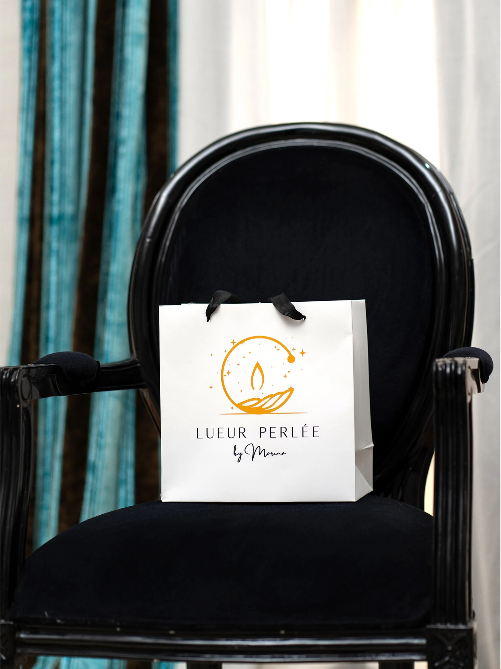 Shopping bag petit modèle Lueur Perlée posé sur un fauteuil.